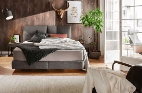 Boxspringbett mit grauem Kopfteil im modernen Schlafzimmer