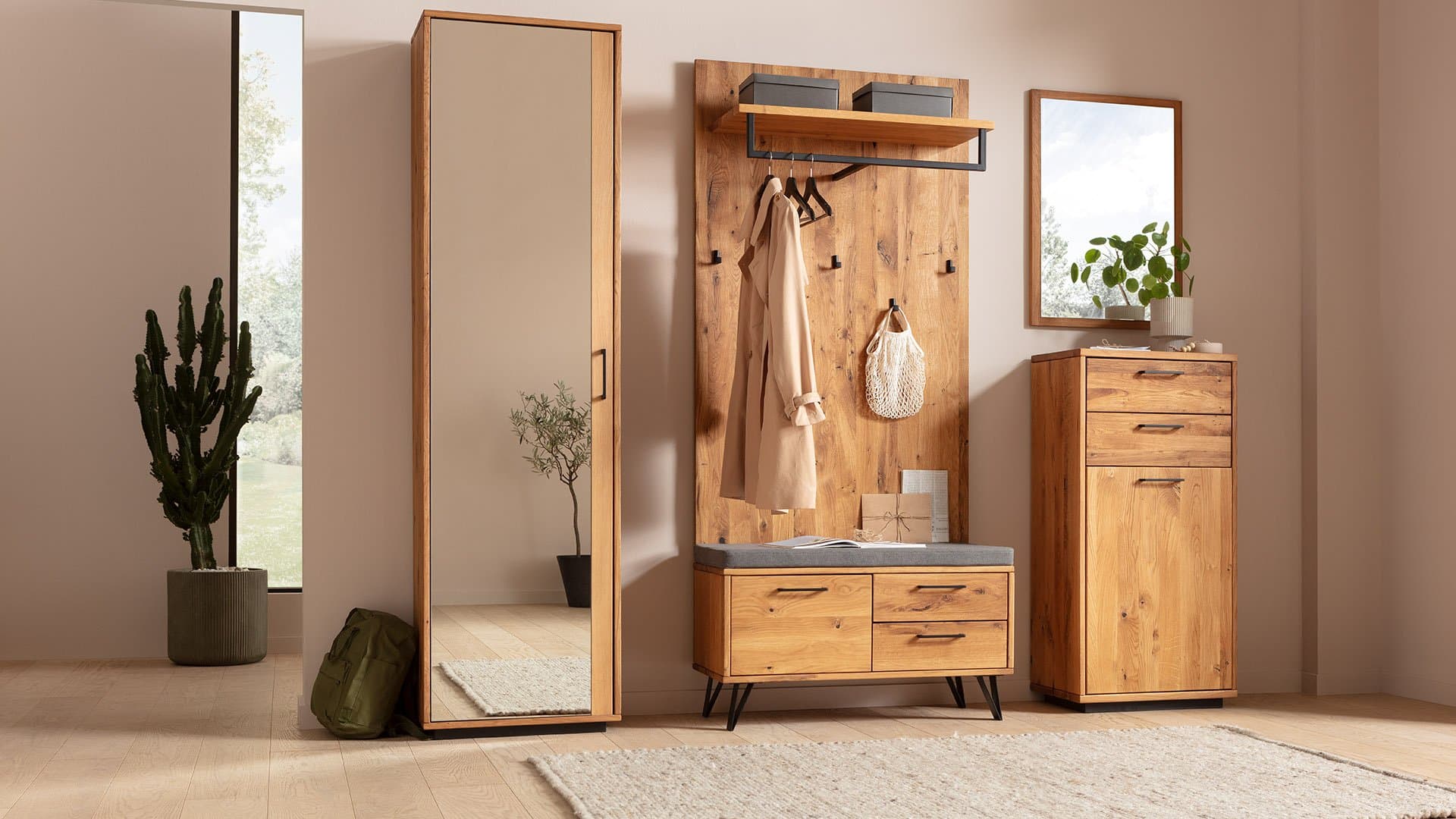 Heller Flur mit Holzschrank, Spiegel, Garderobe und Kaktus, modern und einladend eingerichtet.
