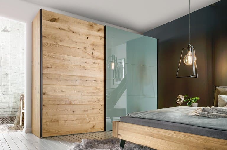Moderne Schlafzimmeransicht mit Holz- und Glastüren, einem Bett und eleganter Beleuchtung.