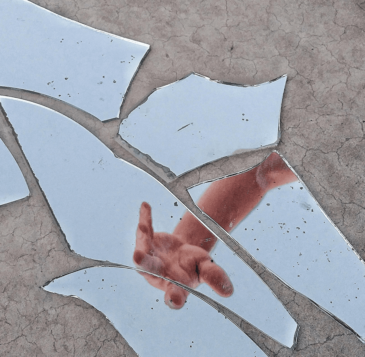 In Spiegelscherben gespiegelte Hand – Symbolbild
